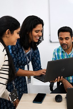 Three ThinkPalm colleagues working through something together on a laptop