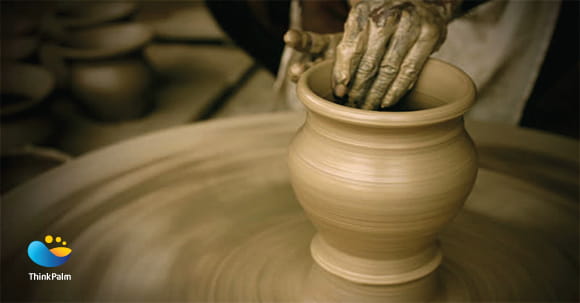 Potter moulding clay on pottery wheel