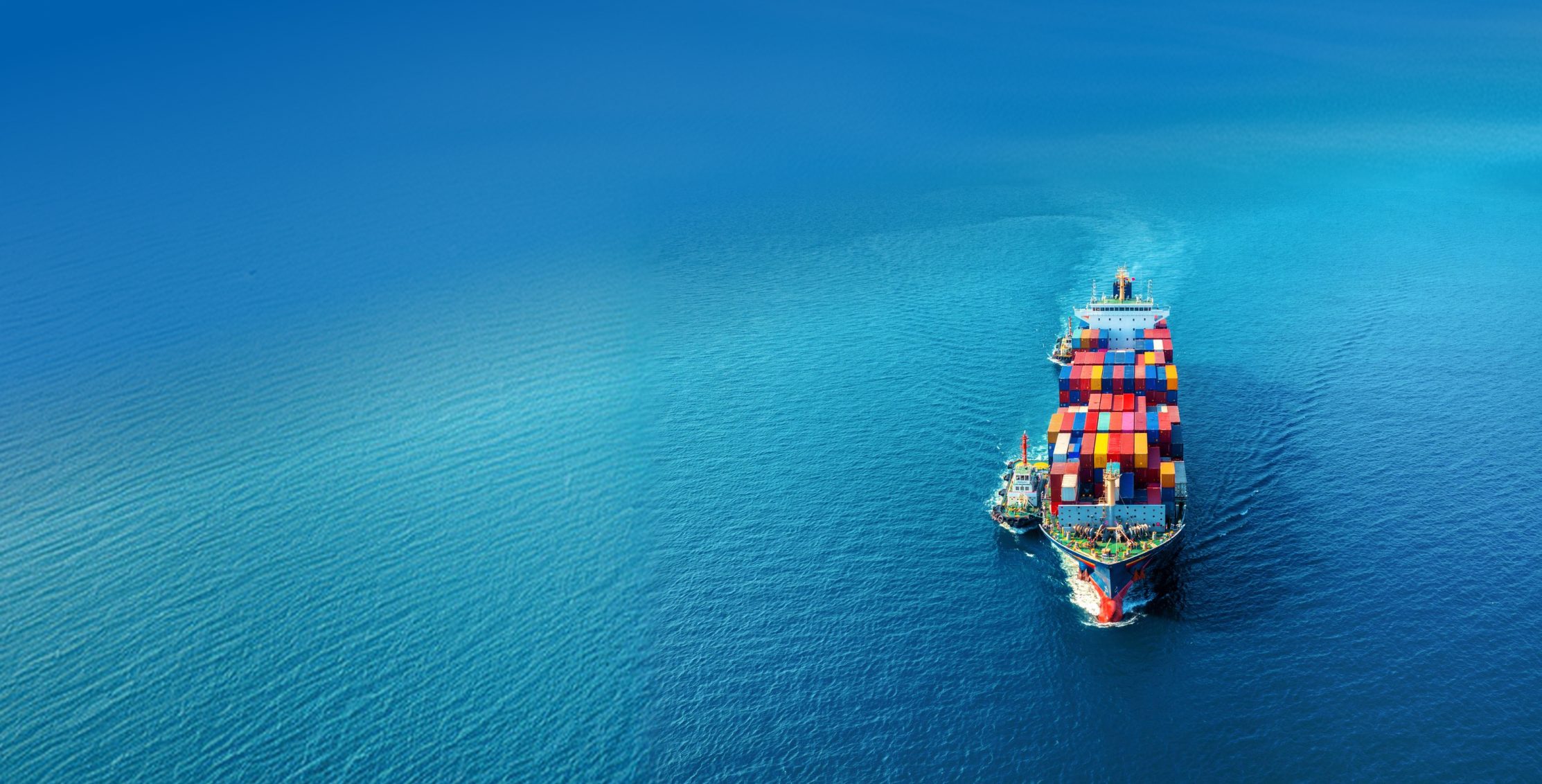 A container ship under way on open water, seen from above